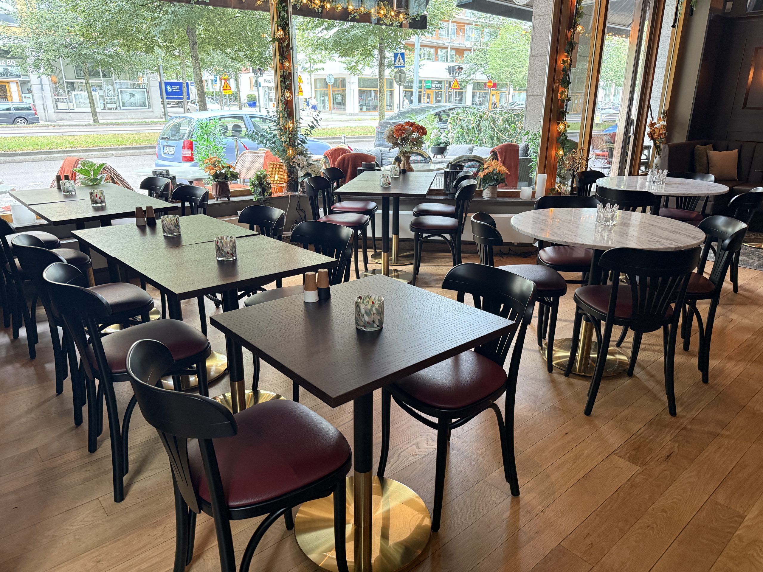 Färdig restauranginredning med mörka stolar och marmorbord